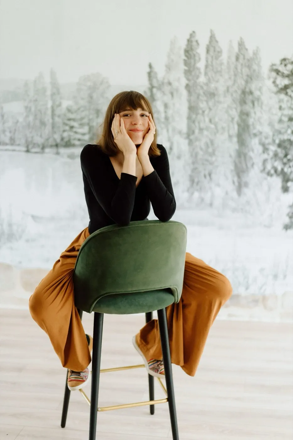 Clara Desse, founder of Crocomaman, sitting on a green velvet chair