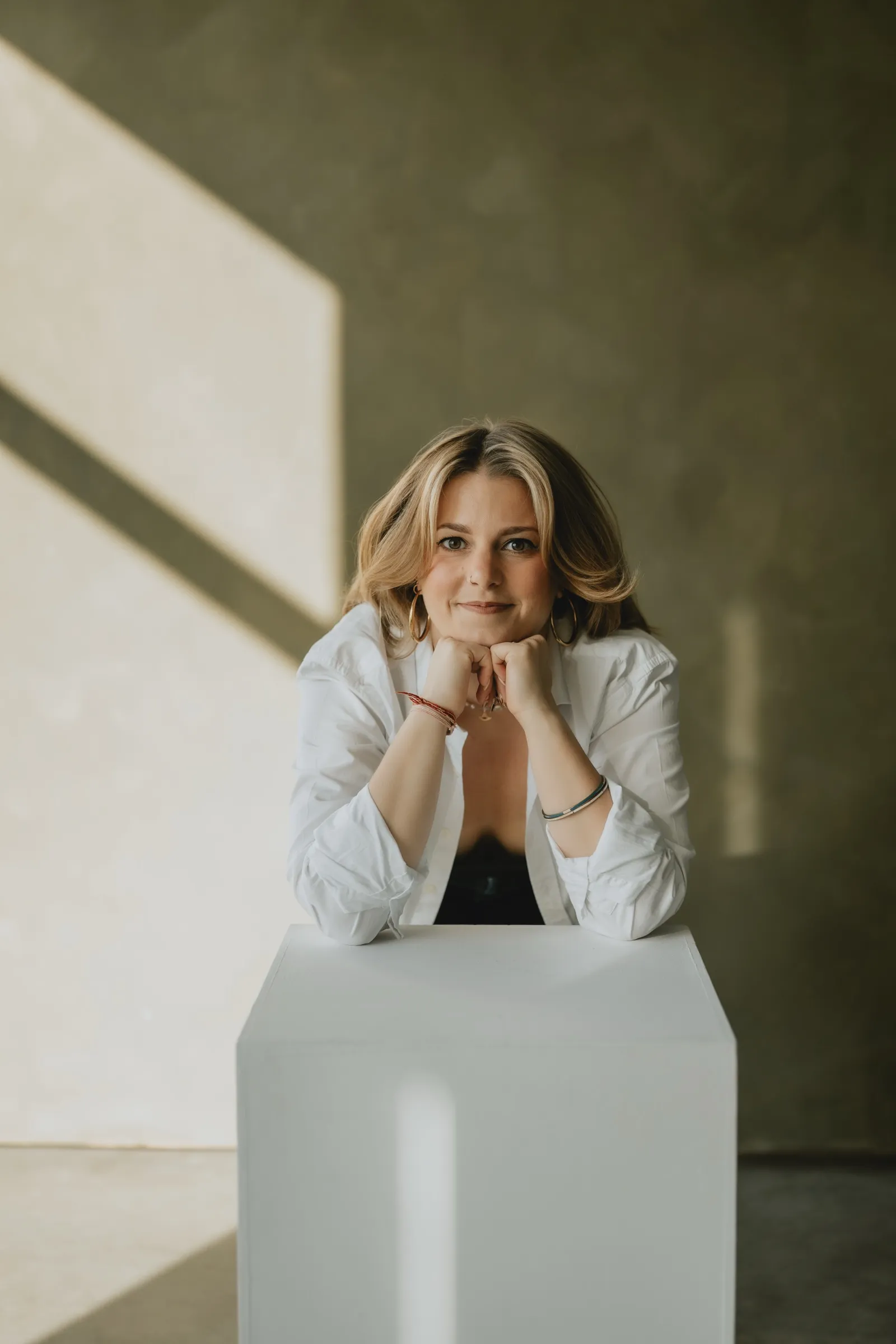 Clémence Tillerot leaning on a white plinth, smiling