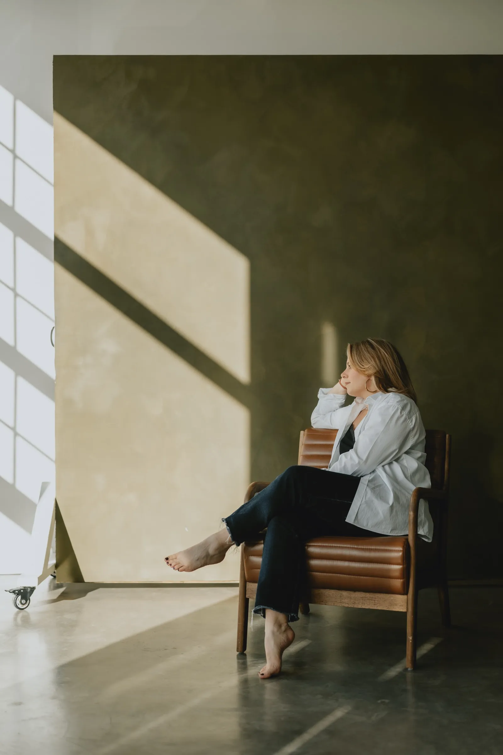 Clémence Tillerot sitting in an armchair by a sunlit window