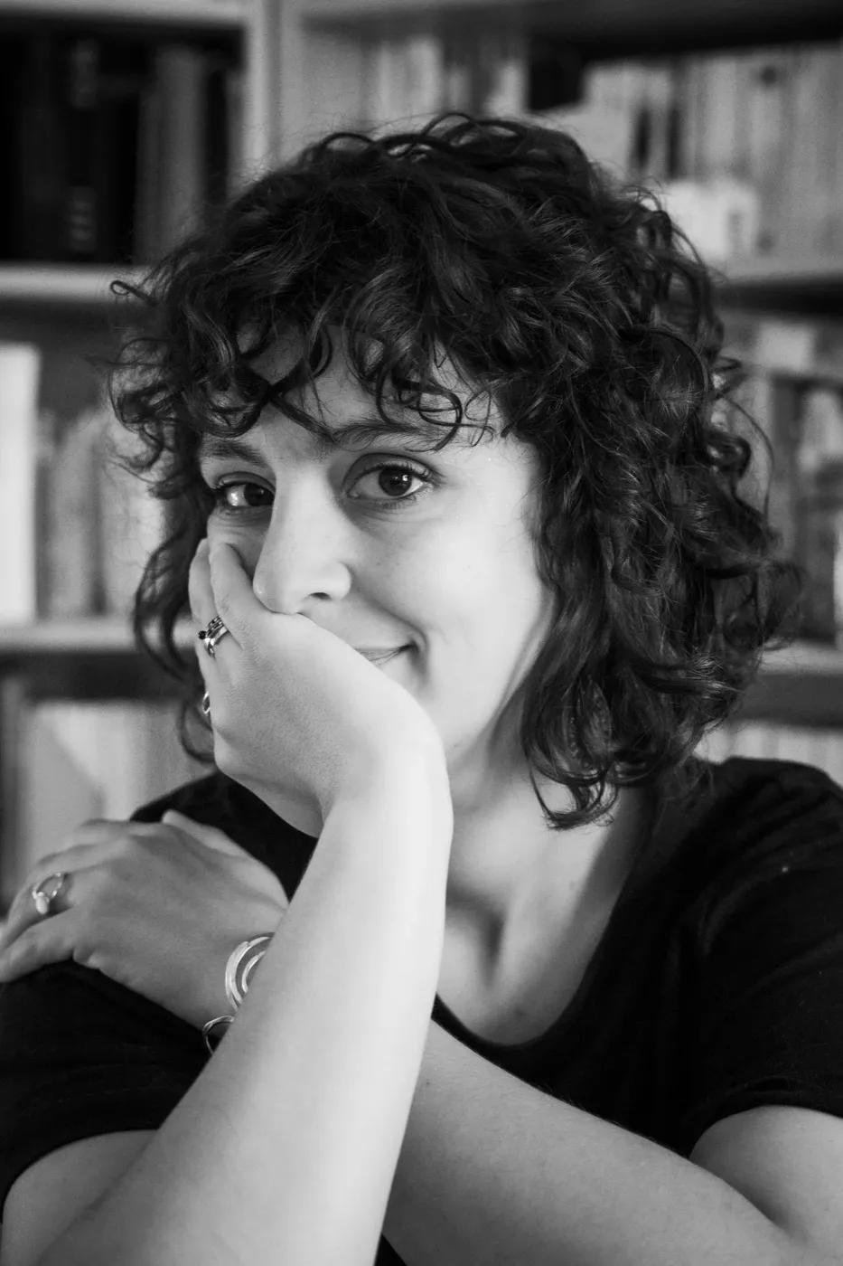 Jennifer Buckle, professional photographer, smiling in front of a bookcase